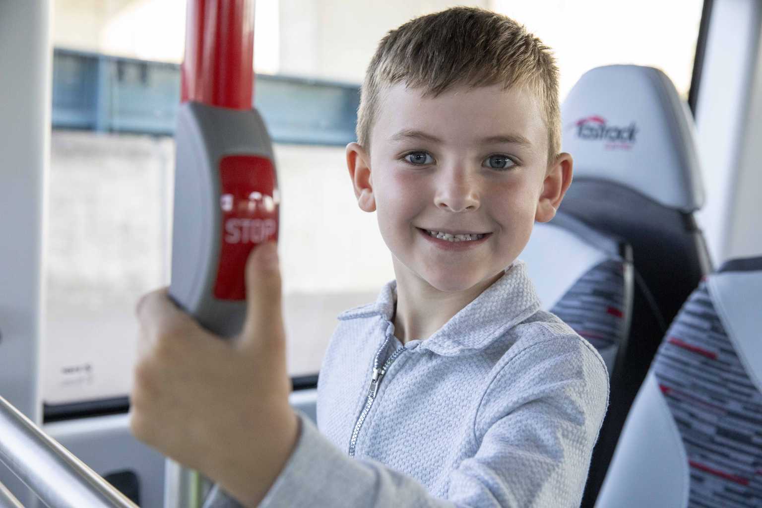 Child pressing the bell on the bus