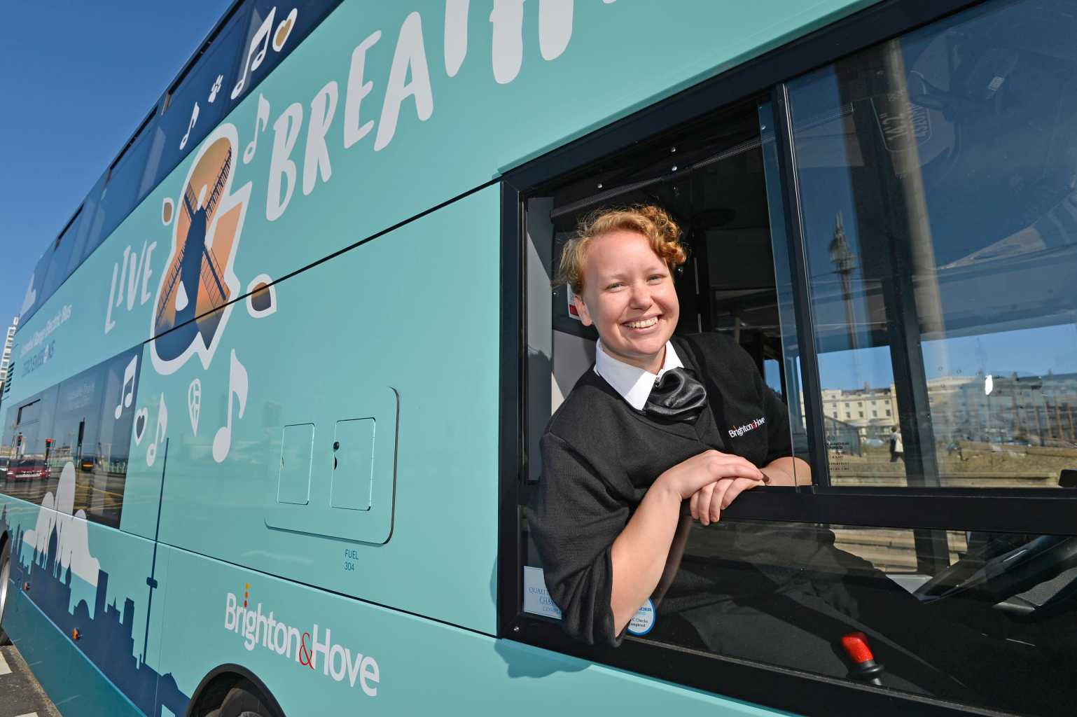 Bus driver smiling and leaning out of her window